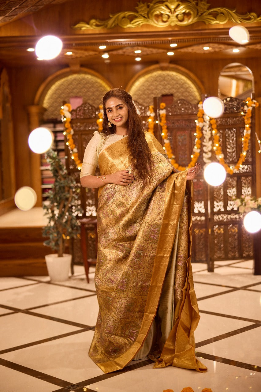 Gold colour Kancheepuram handloom tissue saree with Meena floral design, gold zari border and pallu, paired with matching blouse piece.