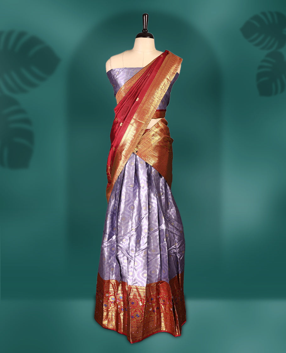 Charming Semi stitiched lavender and red Dhavani set featuring a lustrous lavender skirt with rich golden zari border, paired with a contrasting red dupatta detailed with golden motifs, perfect for festive and wedding occasions.
