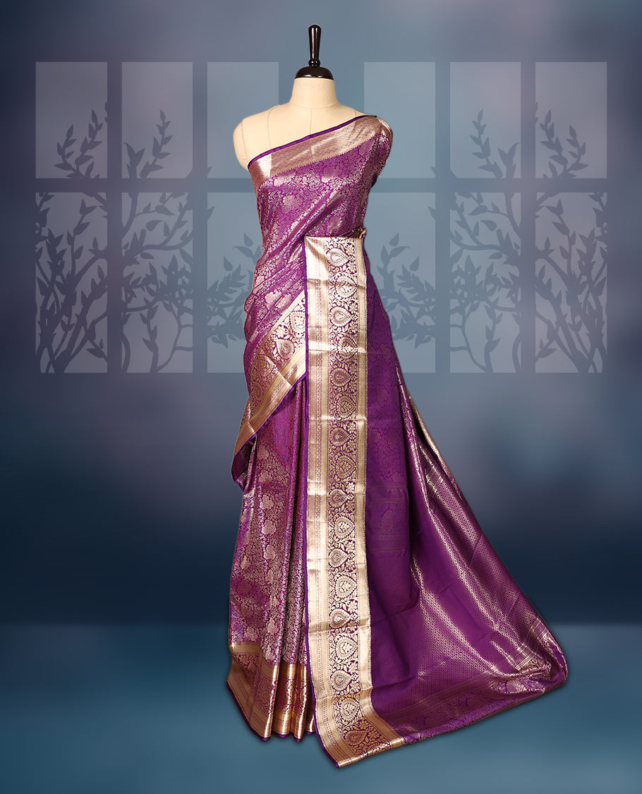 Purple semi silk brocade saree with rich gold zari brocade work all over, complemented by an intricately woven gold border and pallu, Comes with a matching blouse for a grand traditional look.