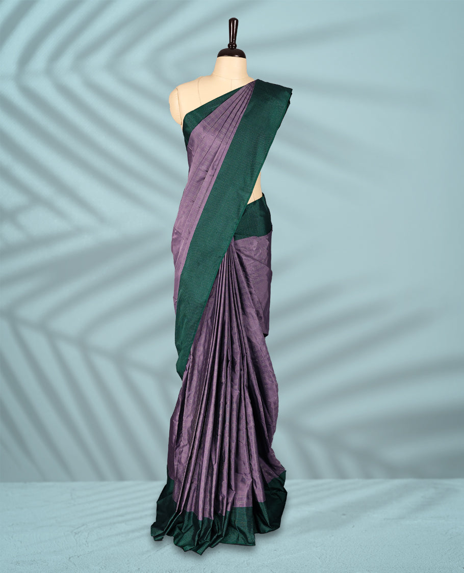 Pastel lavender Colour semi silk saree features a fine checked body design, contrasting deep green textured borders, and comes with a matching blouse.