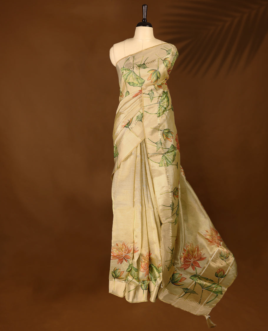 Light gold colour Organza Kerala saree with a sheer, smooth body and soft golden sheen. Accented with a fine zari border and Lotus floral motifs near the pleats. Comes paired with a coordinated matching blouse.