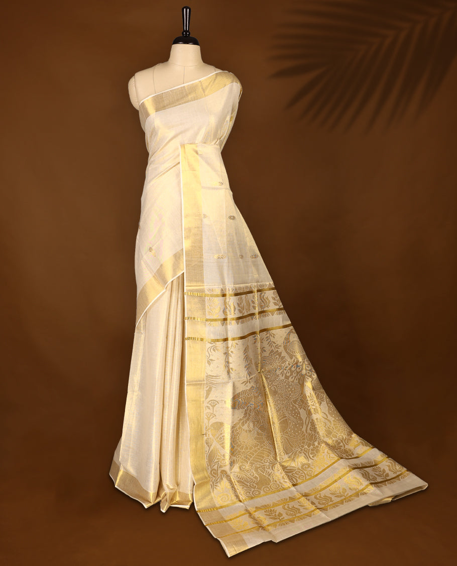 Elegant Light Gold colour Tissue Kerala saree featuring gold zari motifs on body, traditional golden zari kasavu border & Rich Pallu offering a classic and graceful look, paired with a matching blouse.