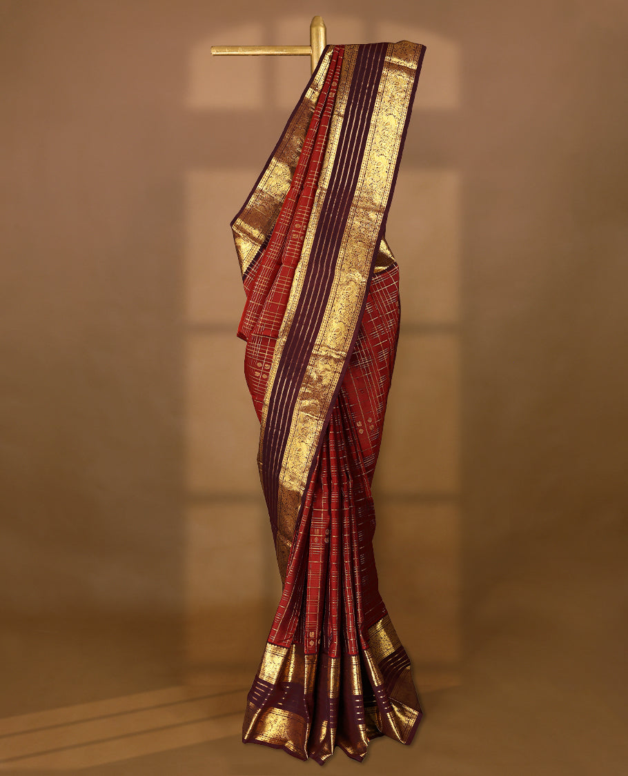 Dark red Colour traditional Kancheepuram silk saree adorned with antique zari check design on the body, featuring a contrasting Traditional border with peacock, deer, and Rudraksham motifs, and paired with a matching blouse.