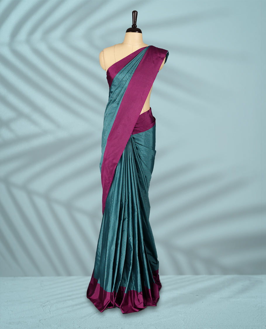Teal green colour body with subtle zari motifs, complemented by a rich magenta border, comes with a matching blouse.