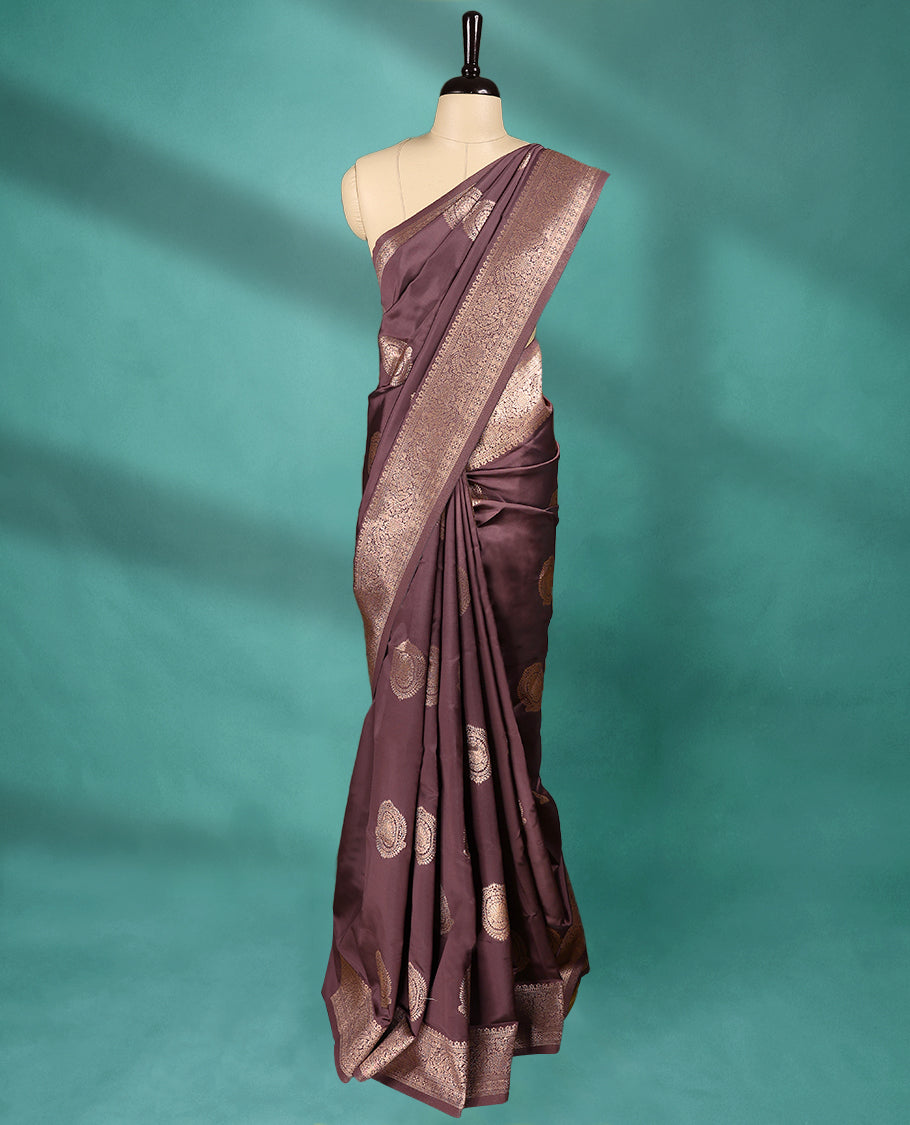 American Brown coloured semi silk saree featuring a Golden Zari Butta design on the body, paired with a Self coloured border and matching blouse.