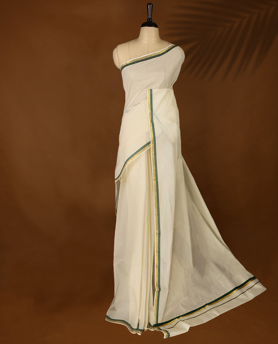 Elegant off white colour cotton Kerala saree featuring a plain body and traditional golden zari border with a hint of Deep Green, offering a classic and graceful look, paired with a matching blouse.
