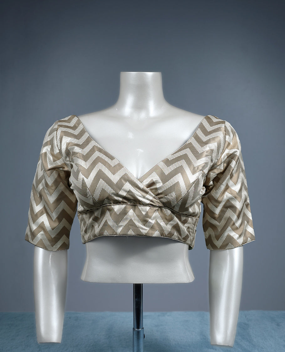 Beige and cream V neck padded readymade blouse featuring a bold chevron pattern with elbow length sleeves, crafted in a glossy fabric for a stylish, contemporary ethnic look.