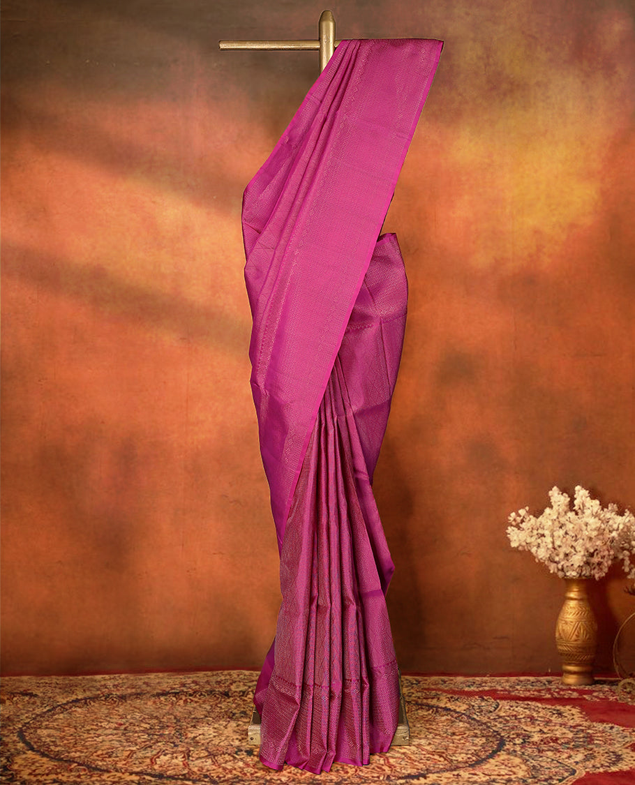 Deep magenta colour pure Mayuri silk saree featuring finely woven Golden zari motifs across the body, detailed with a subtle geometric self border with intricate texture, with matching blouse