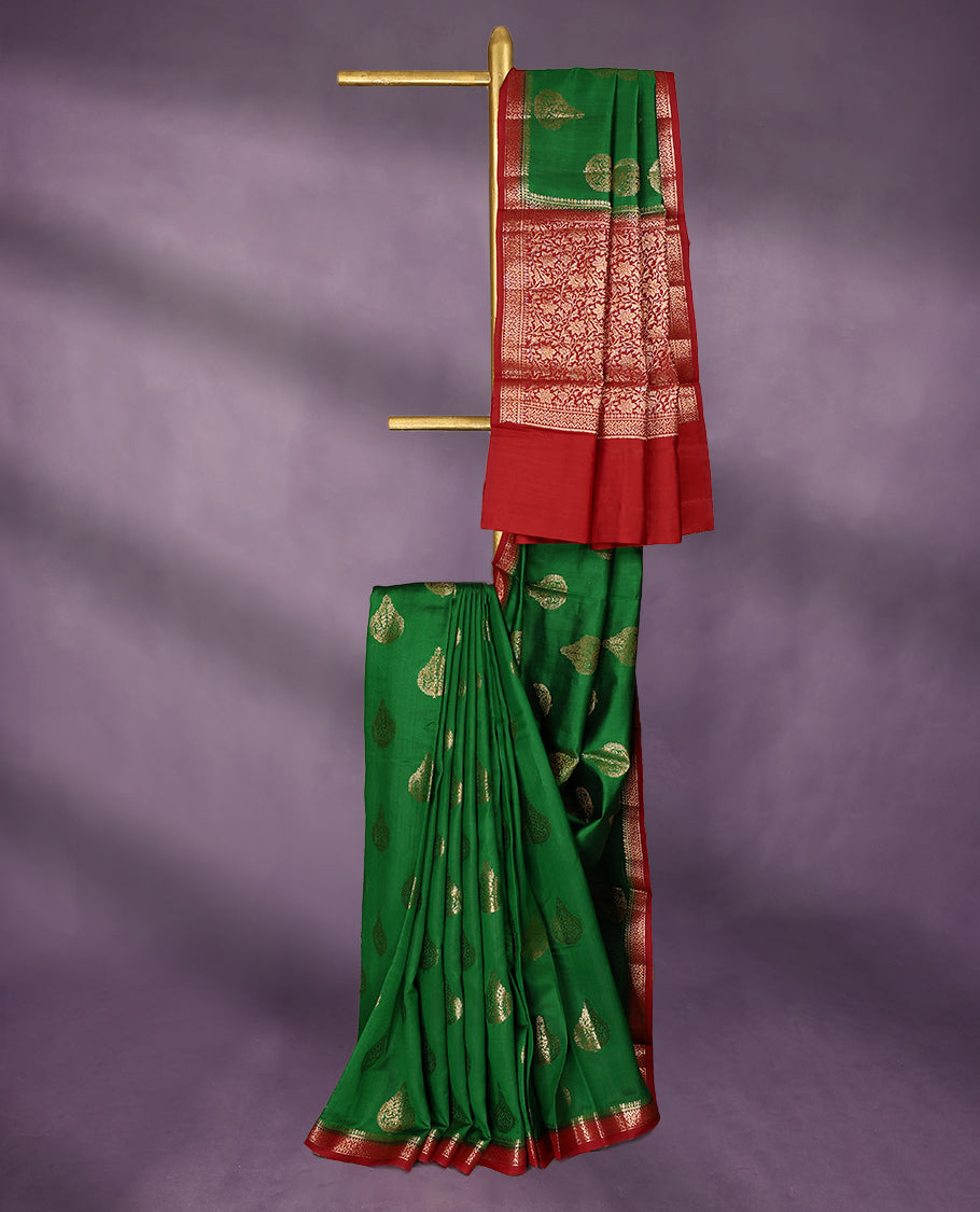 Dark Green Colour Pure Banaras Soft Silk Saree adorned with traditional antique zari motifs, paired with a hand dyed Dark Red antique style border and a matching blouse.