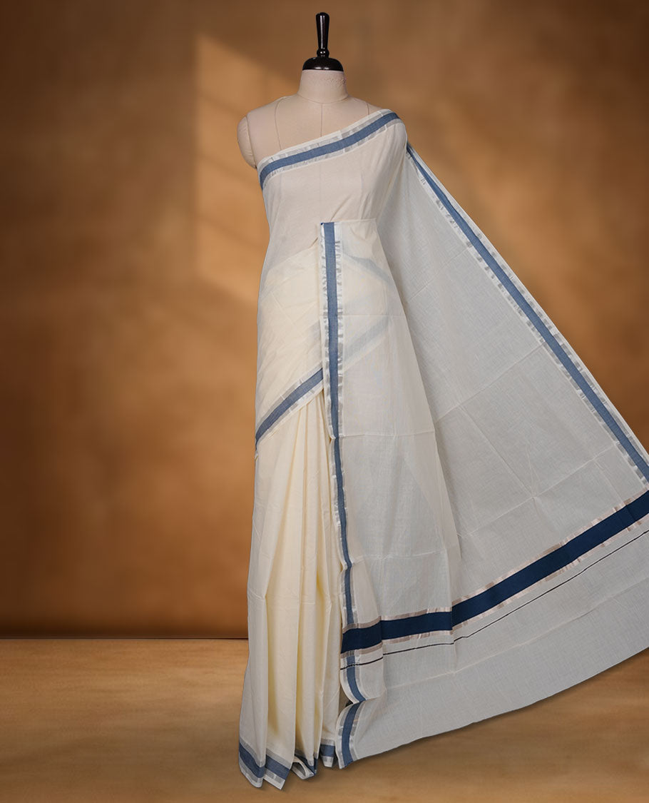 Off-white colour cotton Kerala saree highlighted with teal blue kasavu border, featuring a clean, minimalist body and a graceful flowing pallu, paired with a matching blouse.