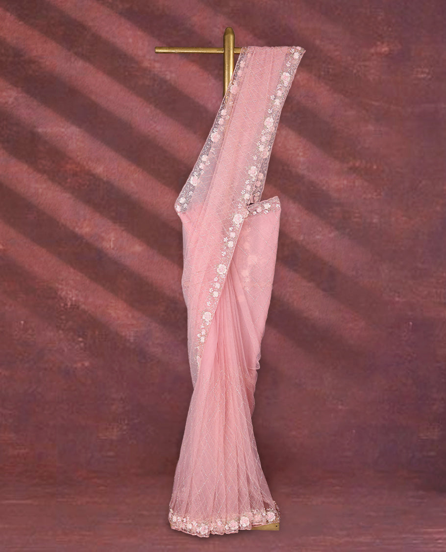 Baby Pink colour net designer saree featuring crisscross cut beads detailing on the body, adorned with beads and sequin worked floral kodi scallop border, paired with a matching worked blouse