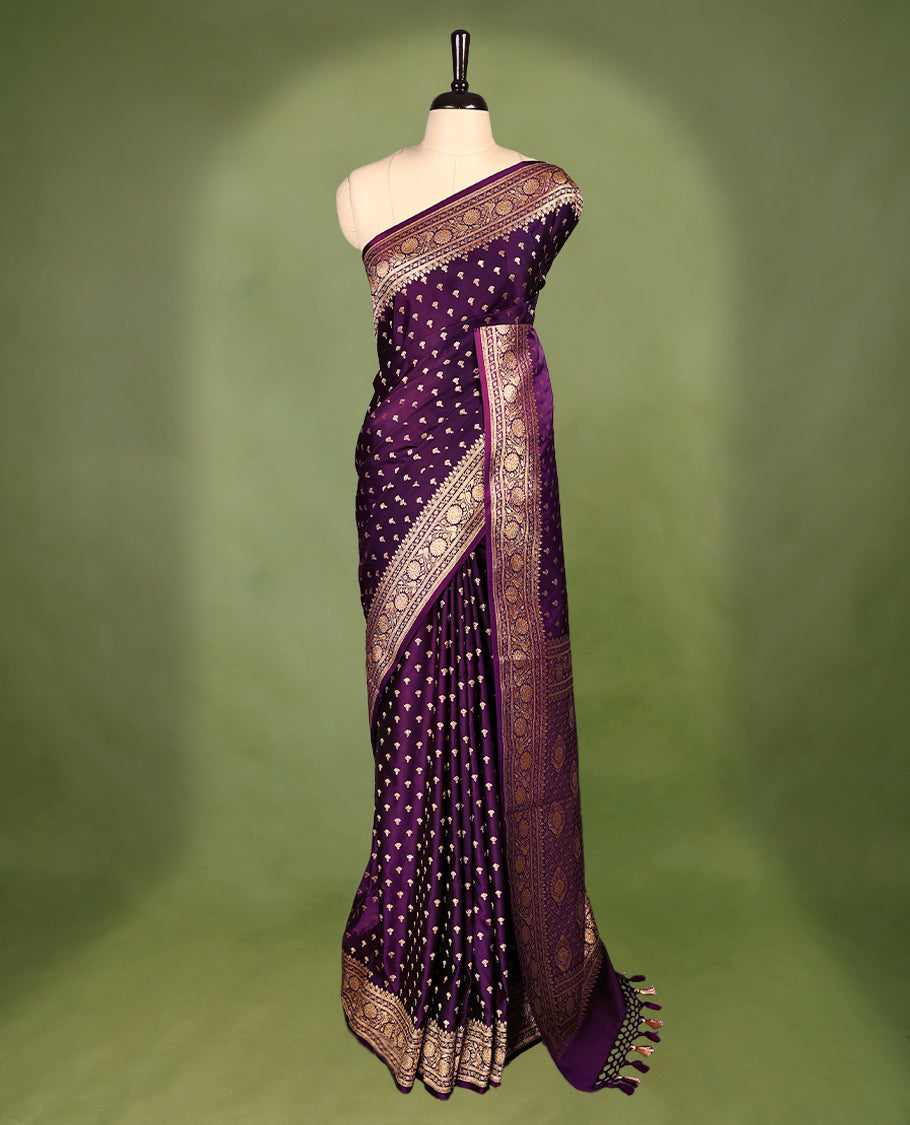 Grape wine colour semi Banaras satin crepe saree featuring gold zari woven small motifs across the body, complemented by an intricately designed traditional banarasi border and richly woven pallu, paired with a matching blouse piece.