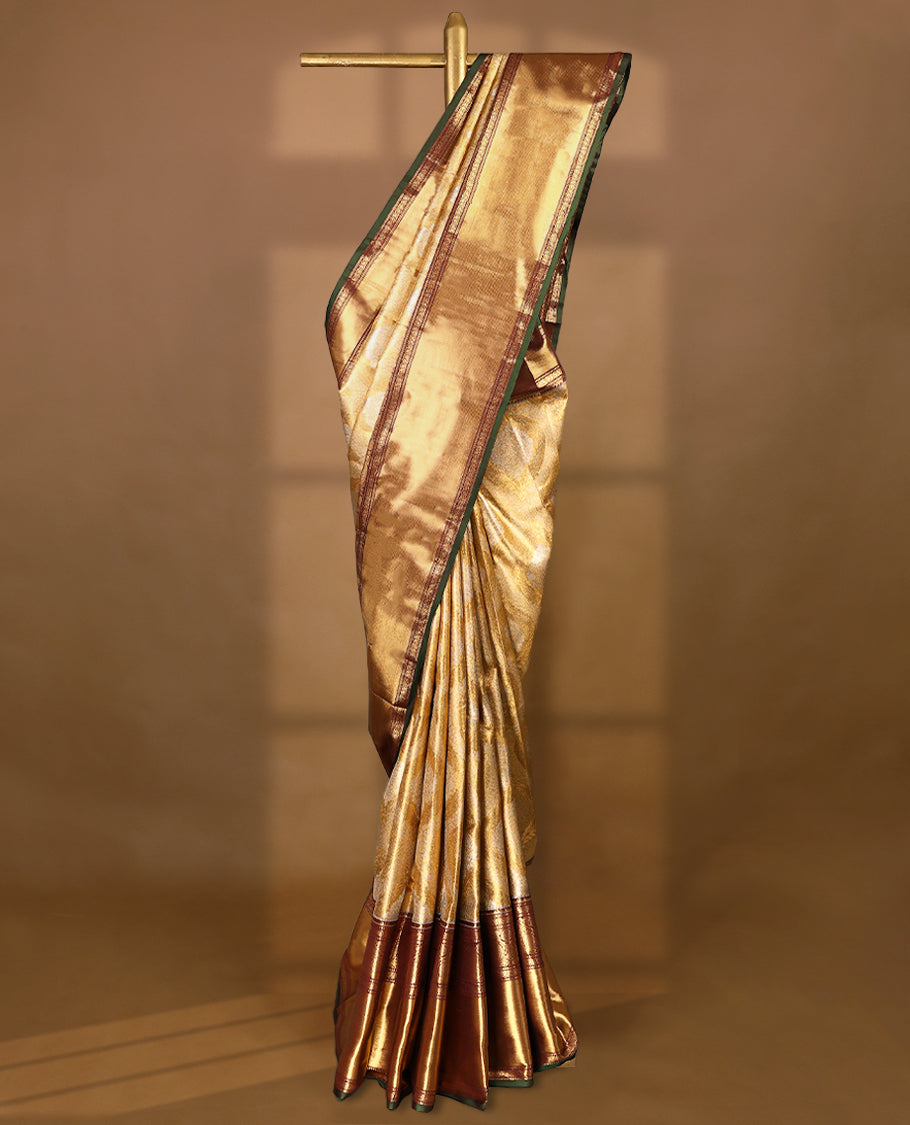 Gold colour tissue brocade saree with gold and silver zari Bold pattern on body, gold zari traditional mango and peacock work brown & green border, rich matching pallu with Antique zari motifs, paired with matching blouse.