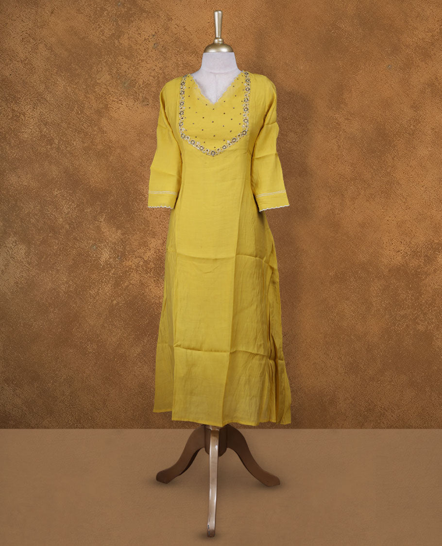Yellow colour kurti with styled with a cut beats pattern around neckline, knee length design, and a sleeve .
