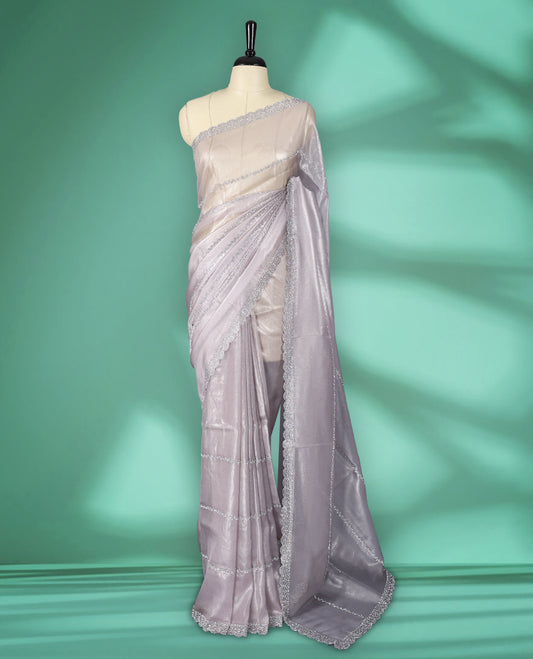Light Pastel Pink colour net shimmer fancy saree adorned with subtle horizontal White stone patterns on the body, paired with a delicate stone worked border, with matching blouse