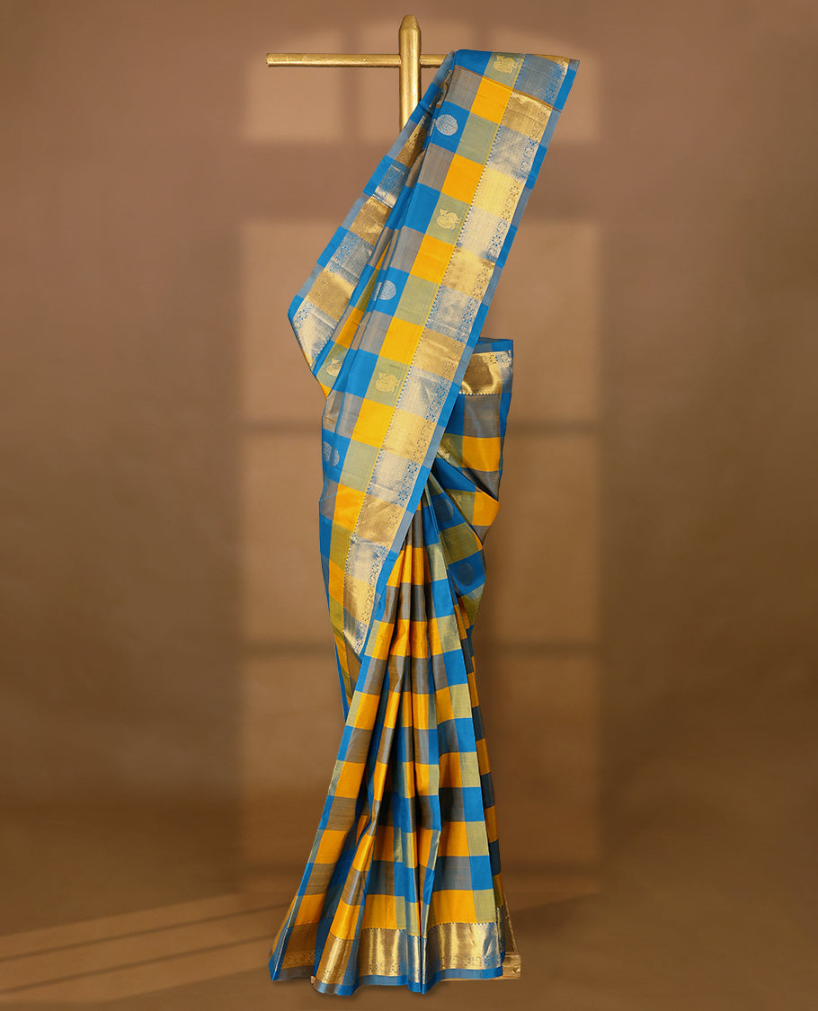 Blue and yellow Checked pure traditional Kancheepuram silk saree featuring antique zari peacock and chakkram motifs on the body, complemented by a traditional border adorned with peacock and diamond motifs, and paired with a matching blouse.