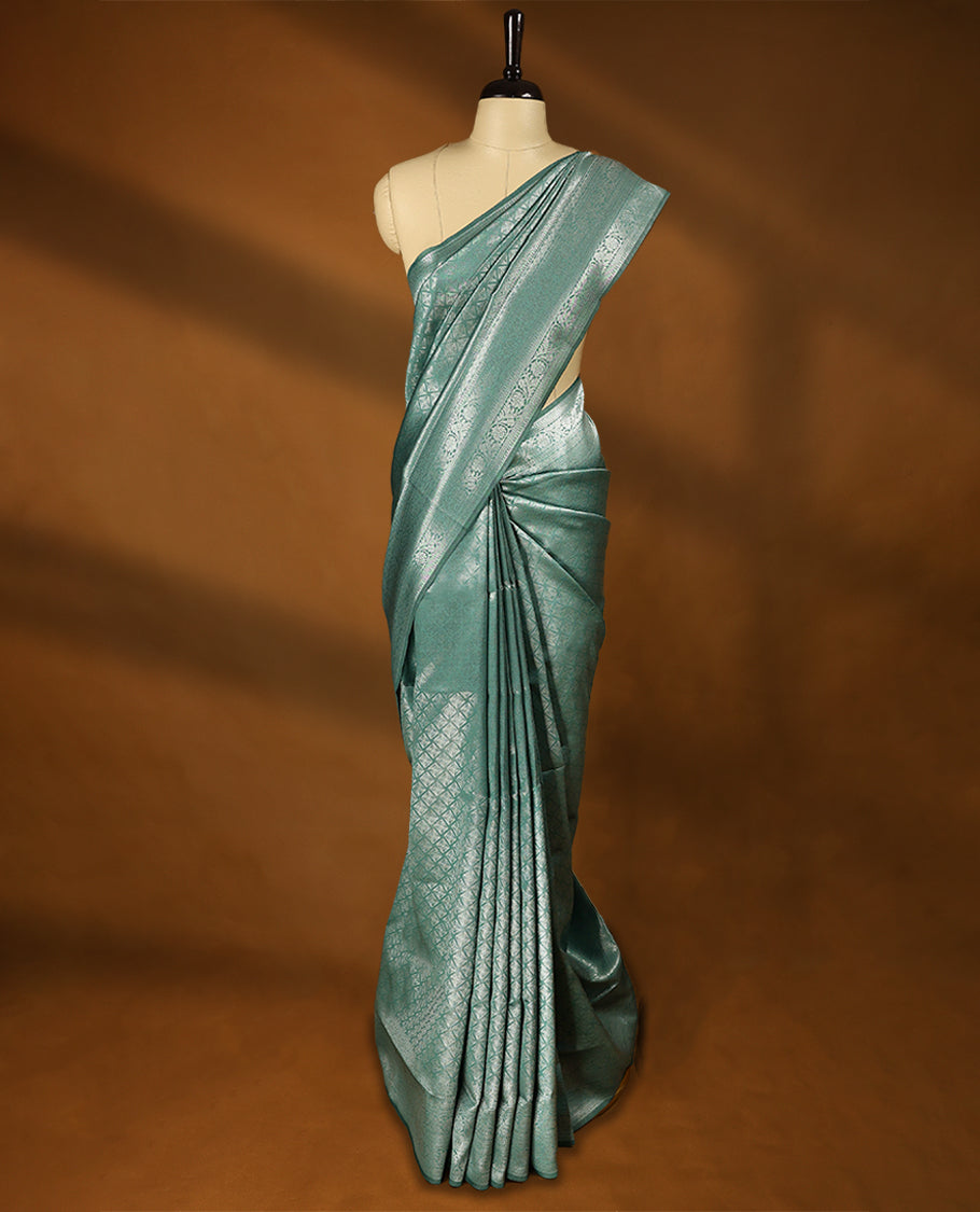 Pastel Aqua coloured semi silk saree featuring a Silver coloured Zari Diamond design on the body, paired with a Self coloured border and matching blouse.