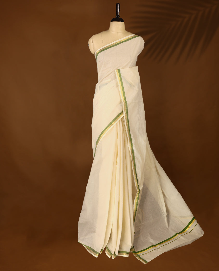 Elegant off white colour cotton Kerala saree featuring a plain body and traditional golden zari border with a hint of Olive Green, offering a classic and graceful look, paired with a matching blouse.