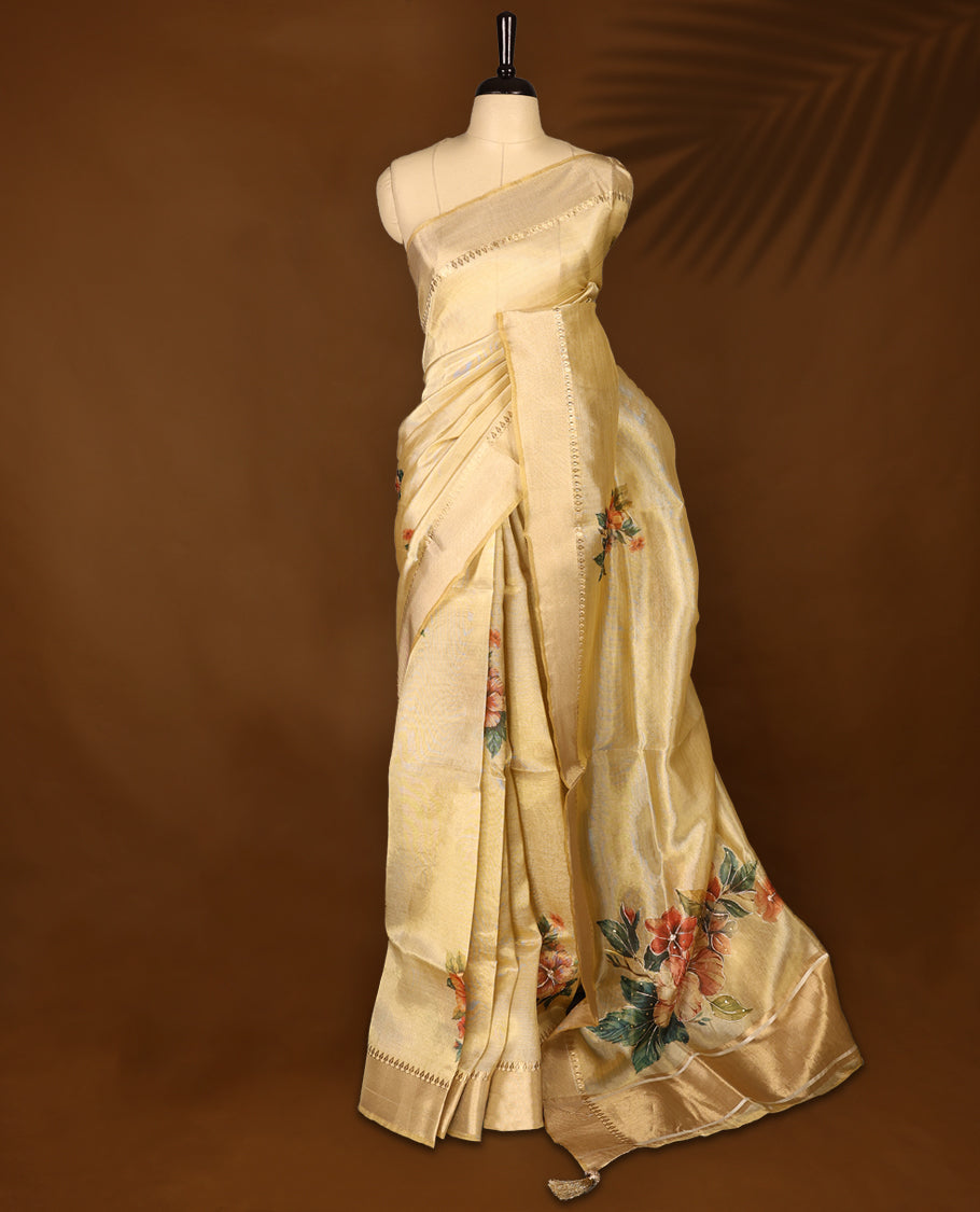 Light gold colour Organza Kerala saree featuring a smooth body with a subtle sheen, highlighted by a sleek golden zari border and delicate floral prints detailed with thread and sequence work near the pleats, Paired with a matching blouse.