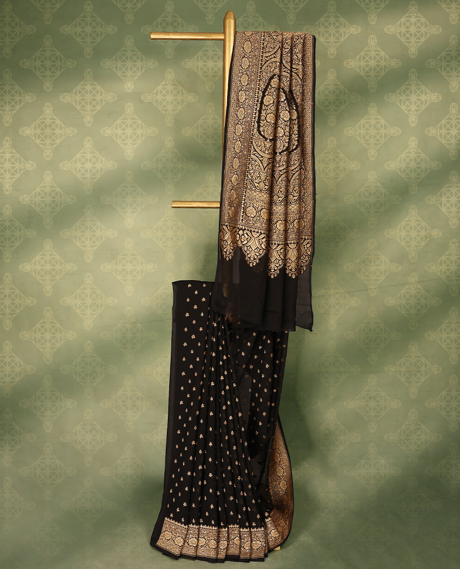 Black colour pure Banarasi georgette saree featuring gold zari Flower Motifs all over the body, complemented by an intricate gold zari Floral Kodi Worked border and pallu, with matching blouse.
