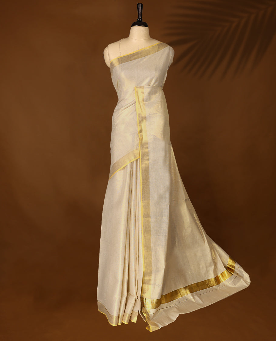 Elegant Light Gold colour Tissue Kerala saree featuring Plain body and traditional Muted golden zari kasavu border offering a classic and graceful look, paired with a matching blouse.