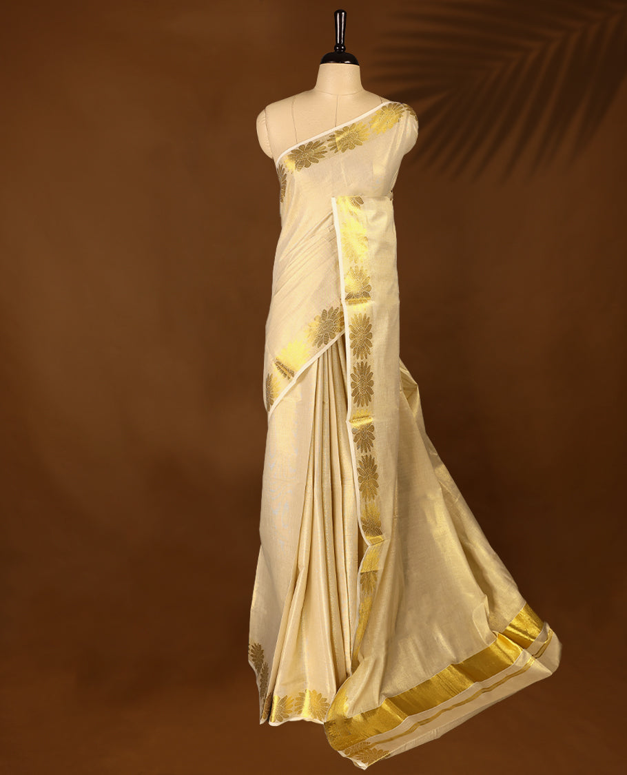 Light Gold colour Tissue Kerala saree featuring Plain body and a beautifully woven Gold Kasavu border with floral motifs, paired with a matching blouse perfect for festive occasions.