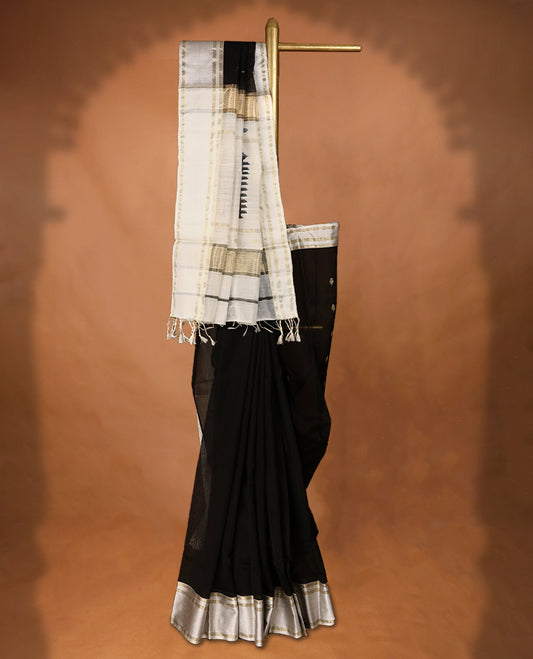 Pure Black coloured Maheshwari Cotton saree featuring  Antique Zari Leaf motifs across the entire body, complemented by a traditional White coloured border and a matching blouse.