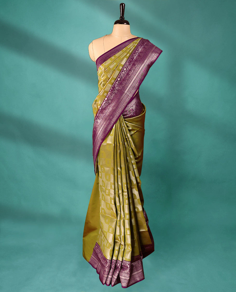 Mung Bean coloured semi silk saree featuring a Silver coloured Zari design on the body, paired with a Grape coloured border and matching blouse.