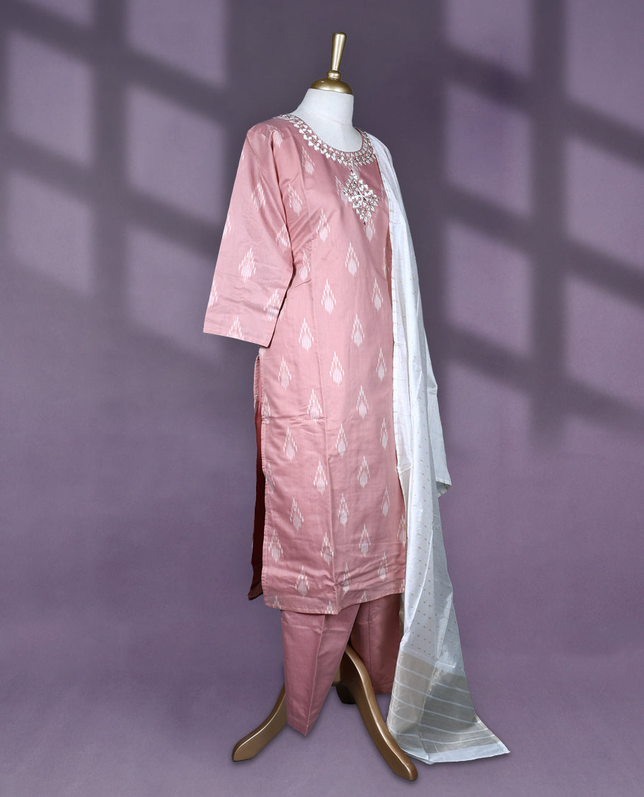 Dusty pink colour salwar set featuring ikat style motifs and delicate mirror work on the neckline, paired with matching plain bottom and an elegant off white dupatta with subtle golden thread detailing.