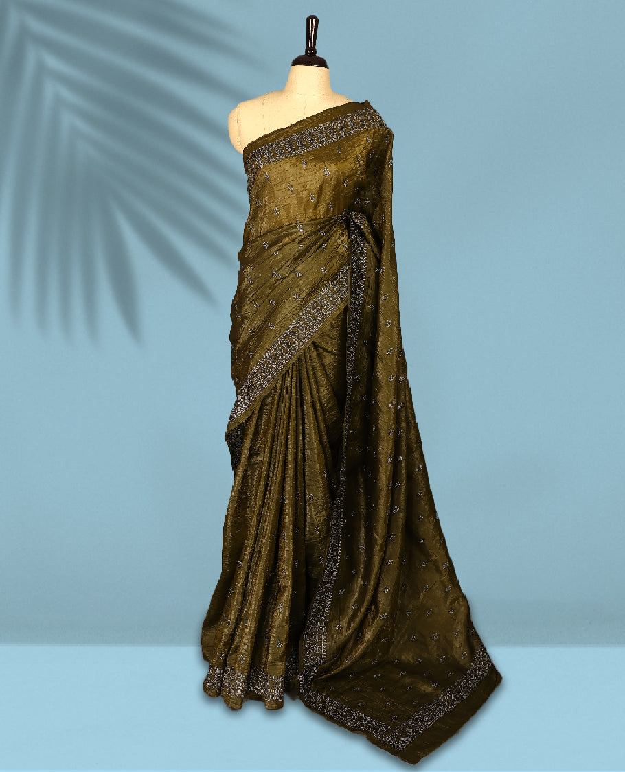 Olive Colour crush soft silk saree, textured body with a natural crinkled finish, adorned with intricate Silver colored floral Motifs and complemented by a delicate Silver Zari embroidery border, paired with a matching blouse