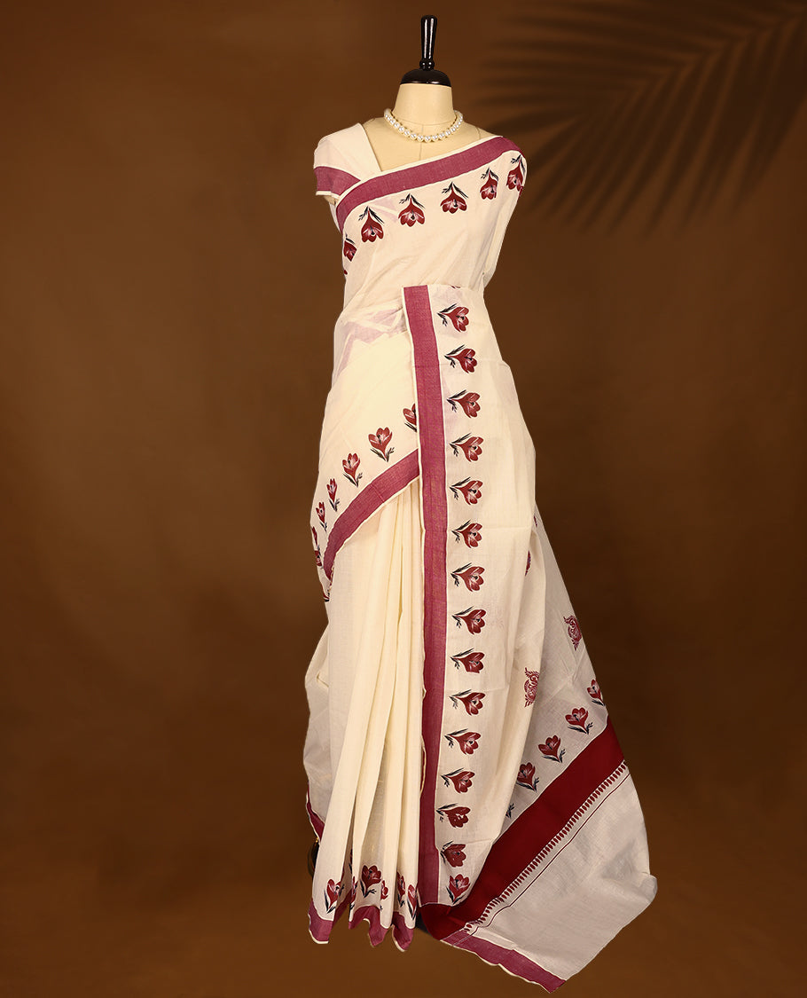 Kerala cotton saree showcases charming red floral Prints complemented by a deep maroon border with Matching Blouse
