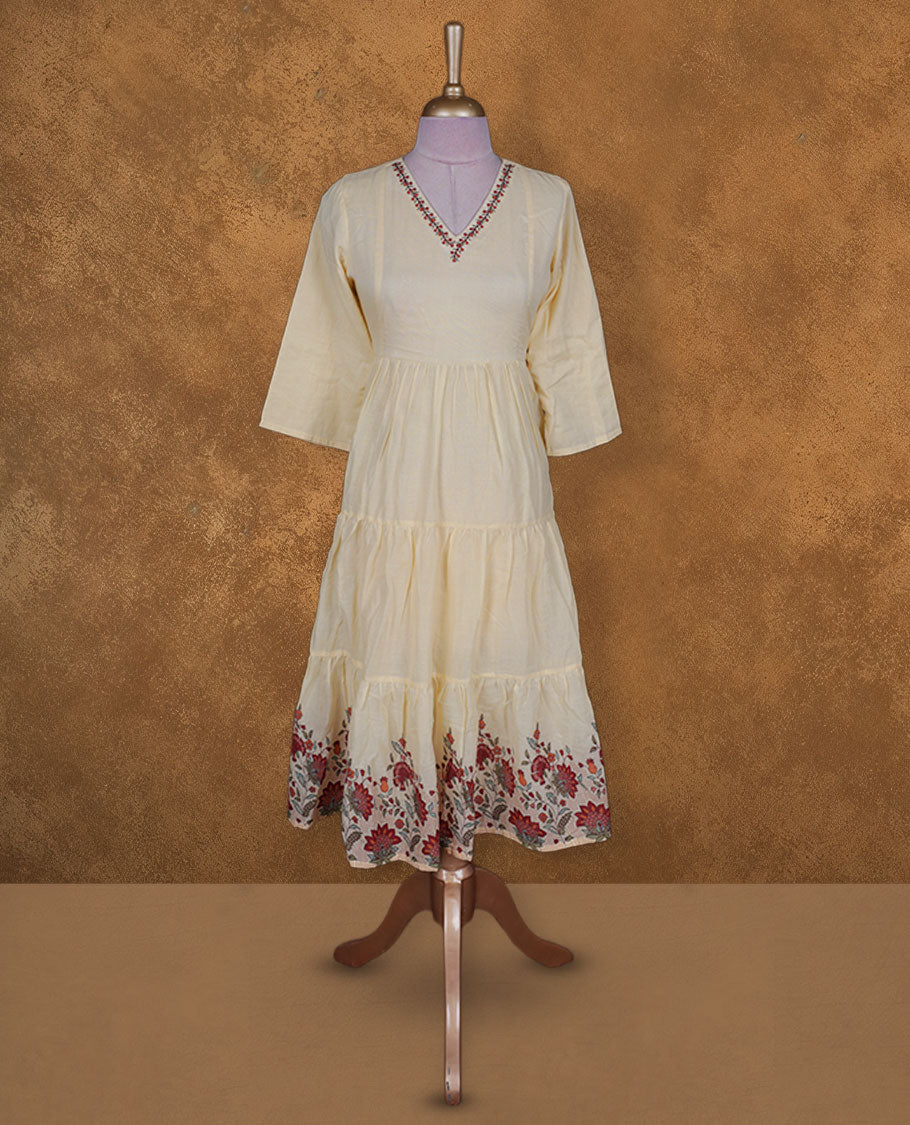 Soft cream yellow colour kurti BY VISMAY with floral printed hem, featuring a V neckline with embroidery, three quarter sleeves, and a tiered knee length silhouette.