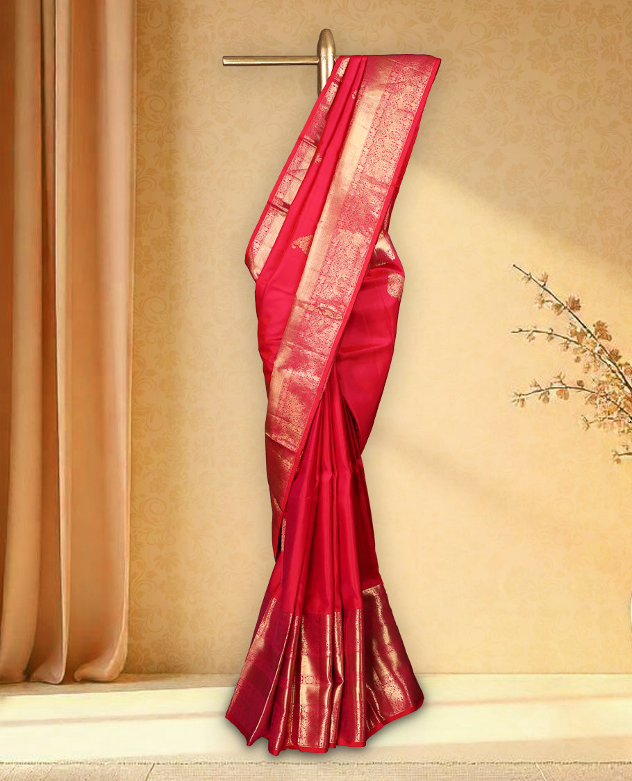 Rani pink colour pure Kancheepuram saree with gold zari Banarasi paisley mango motifs on the body traditional border with elephant peacock and chackram pattern grand pallu with floral chackara motifs paired with matching blouse