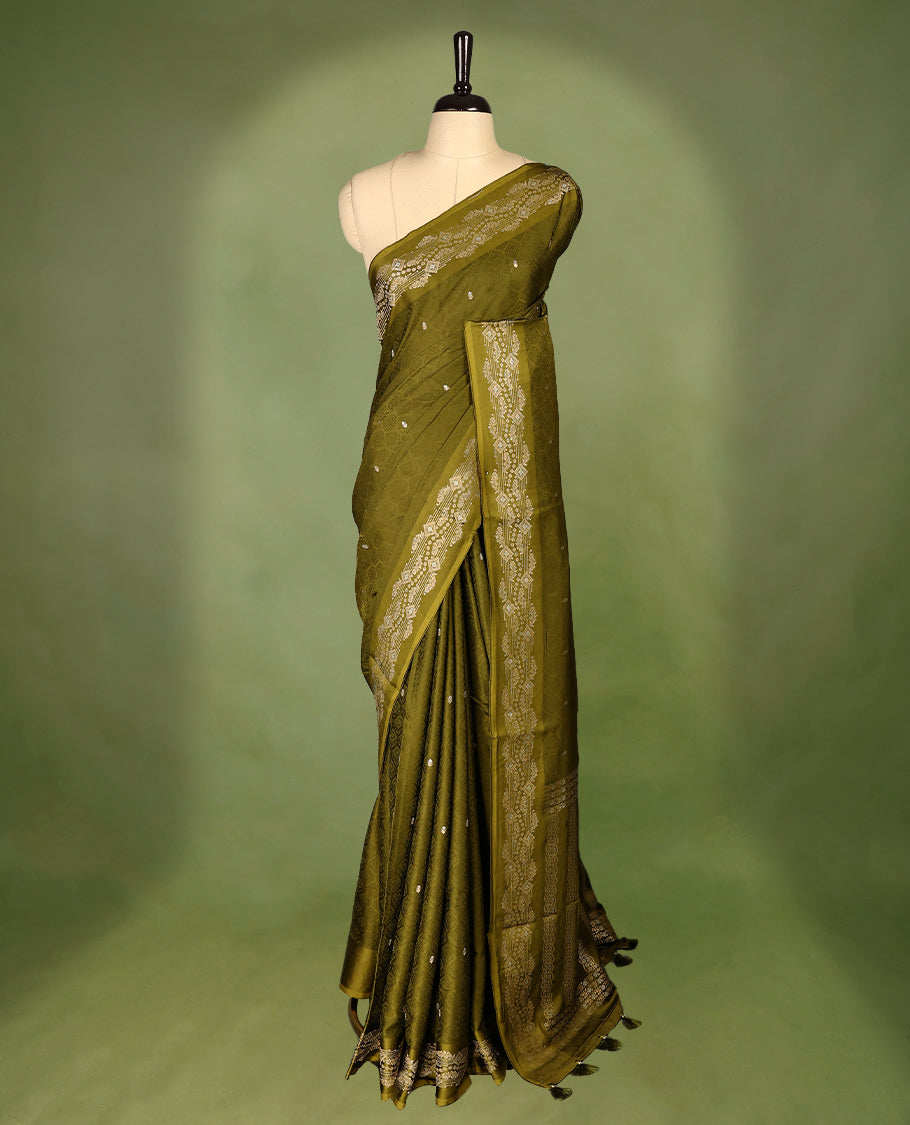 Olive Green colour pure Banaras crepe saree showcases elegant Gold & Silver zari Motifs all over the body, a traditional gold & Silver zari border, a rich intricately woven pallu, and comes with a matching blouse.