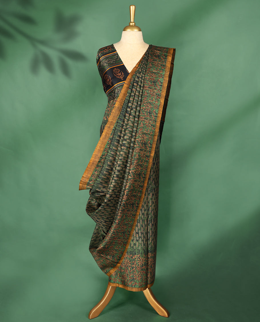 Deep green colour Manipuri saree features a body adorned with intricate Block motifs, complemented by a rich golden yellow Floral Printed border, and comes with a matching blouse.