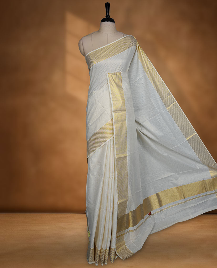 Off white colour Kerala cotton saree featuring fine golden stripes, complemented by a classic zari border and traditional pallu, paired with a matching blouse.