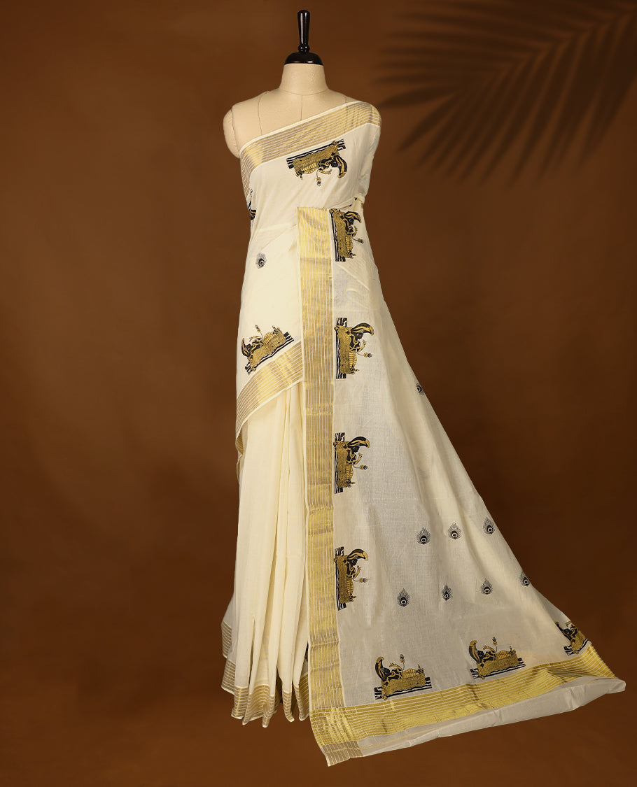 Elegant off white colour cotton Kerala saree featuring peacock feather prints on body, Gold kasavu border with Lord Vishnu, offering a classic and graceful look, paired with a matching blouse.
