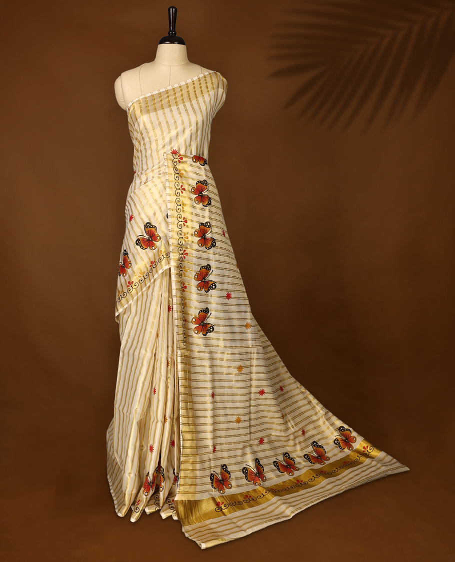 Elegant off white tissue Kerala saree featuring golden stripes and vibrant orange butterfly motifs, enhanced with a traditional golden zari border, offering a graceful and artistic look, paired with a matching blouse.