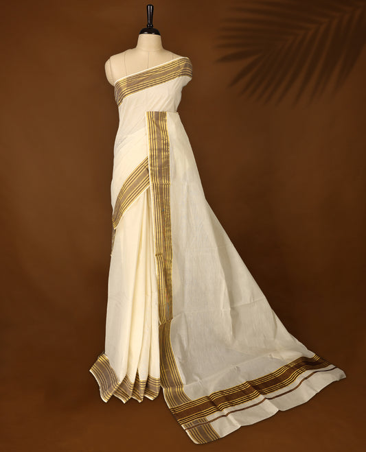 Classic off white colour Kerala cotton saree with rich brown and gold striped border, Lightweight and breathable, it comes with a matching blouse & perfect for traditional functions and everyday elegance.