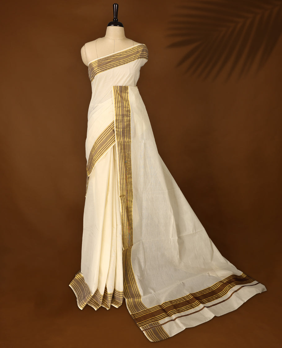 Classic off white colour Kerala cotton saree with rich brown and gold striped border, Lightweight and breathable, it comes with a matching blouse & perfect for traditional functions and everyday elegance.
