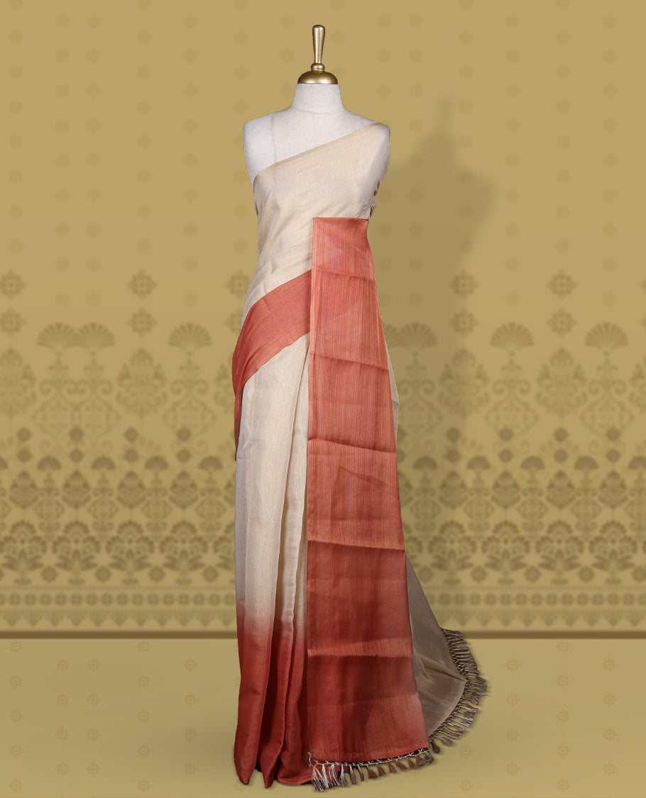 Beige and rust orange colour saree, featuring a smooth woven texture, The shaded rust pallu adds a refined charm & Finished with tassel detailing and comes with a matching blouse piece.