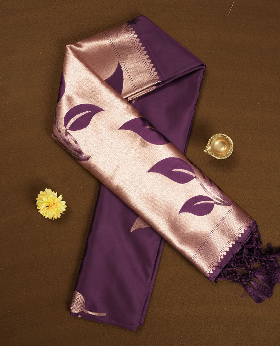 Dark purple colour semi silk saree adorned with elegant leaf motifs on the body, complemented by a shimmering golden zari-woven pallu and border, and paired with a matching blouse