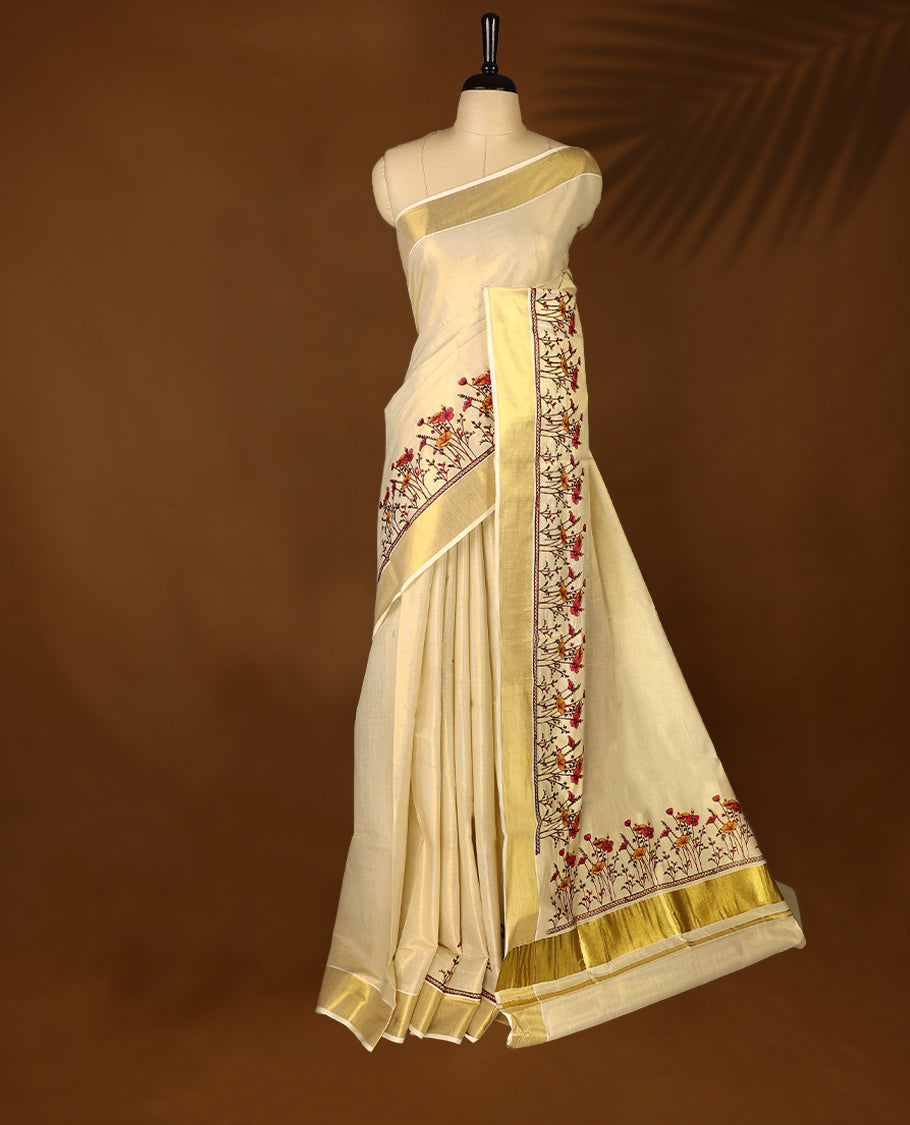 Light Gold colour Tissue Kerala saree featuring Plain body and a beautifully woven Gold Kasavu border with Heavy Floral embroidery work, paired with a matching blouse perfect for festive occasions.
