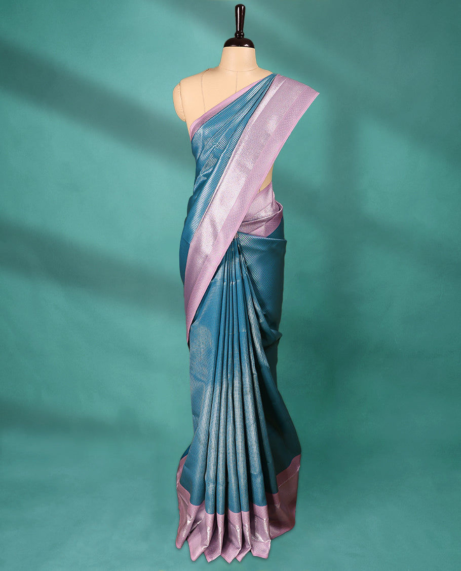 Blue coloured semi silk saree featuring a Check design on the body, paired with a Pastel Pink coloured border and matching blouse.