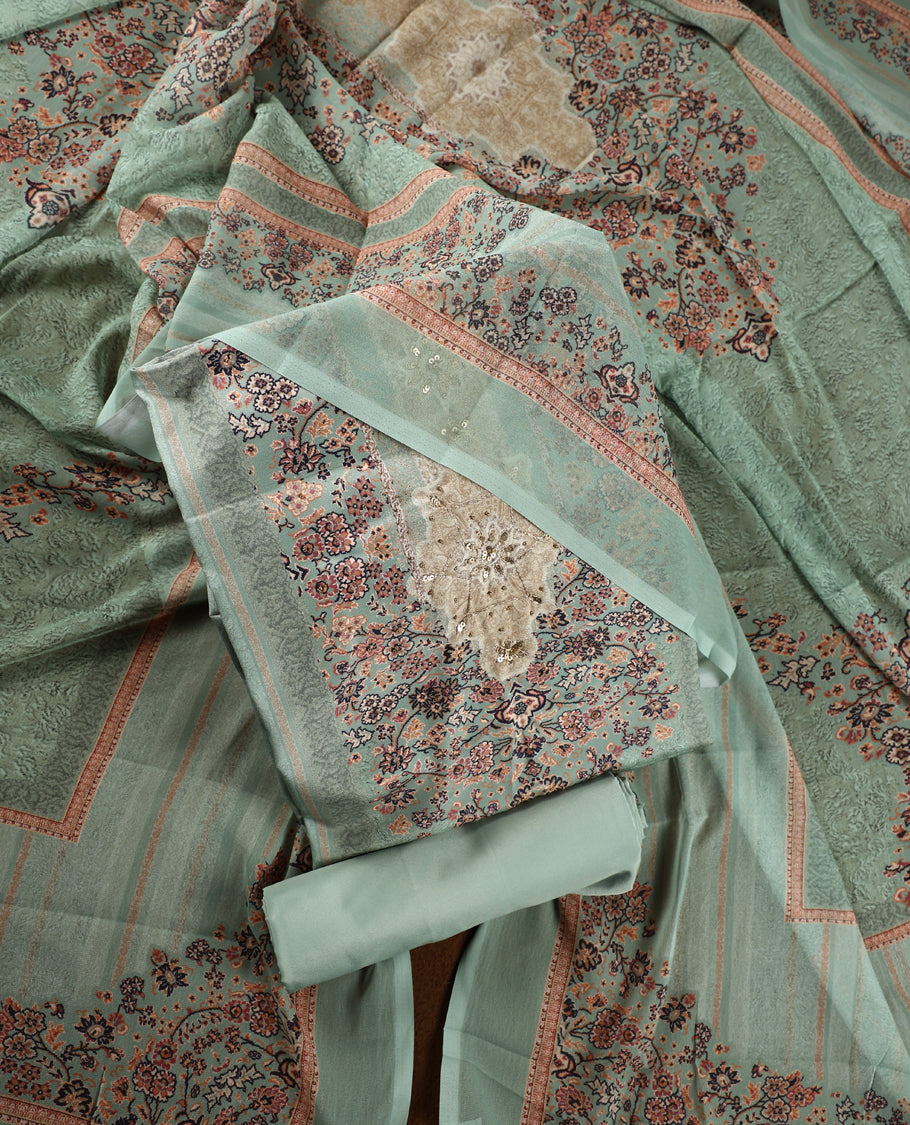 Pista green colour churidhar material with intricate floral prints, sequin embroidery on the top, plain matching bottom, and a coordinated dupatta.