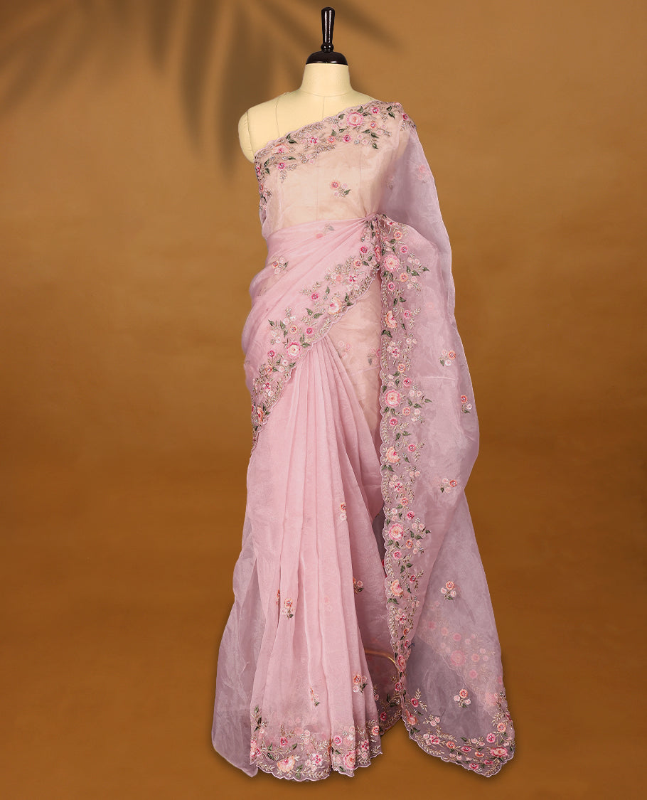 Pastel Pink Organza Tissue Silk Saree is beautifully adorned with intricate pink floral embroidery Border and a matching blouse.