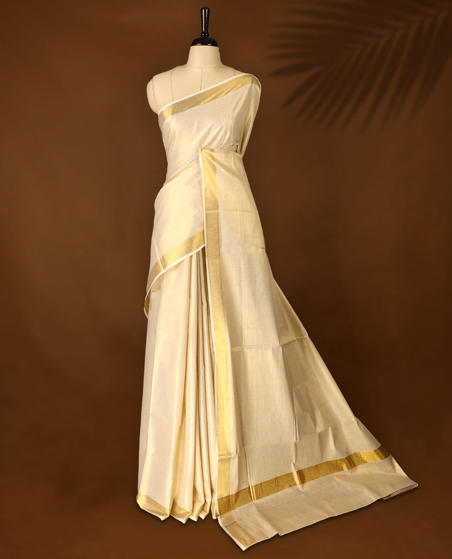 Elegant Light Gold colour Tissue Kerala saree featuring Plain body and traditional golden zari 2.5 Inch kasavu border offering a classic and graceful look, paired with a matching blouse.