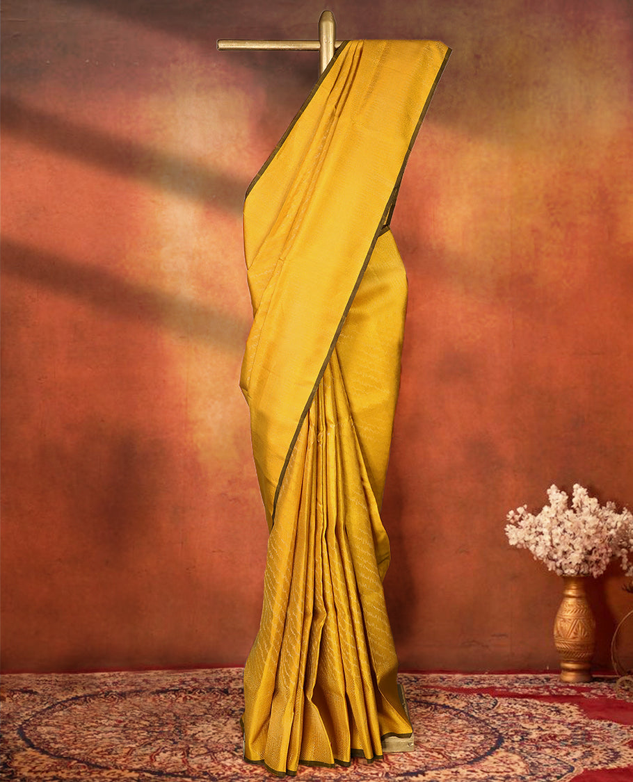 Yellow colour pure Mayuri silk saree featuring finely woven Golden zari motifs across the body, detailed with a subtle geometric self border with intricate texture, with matching blouse