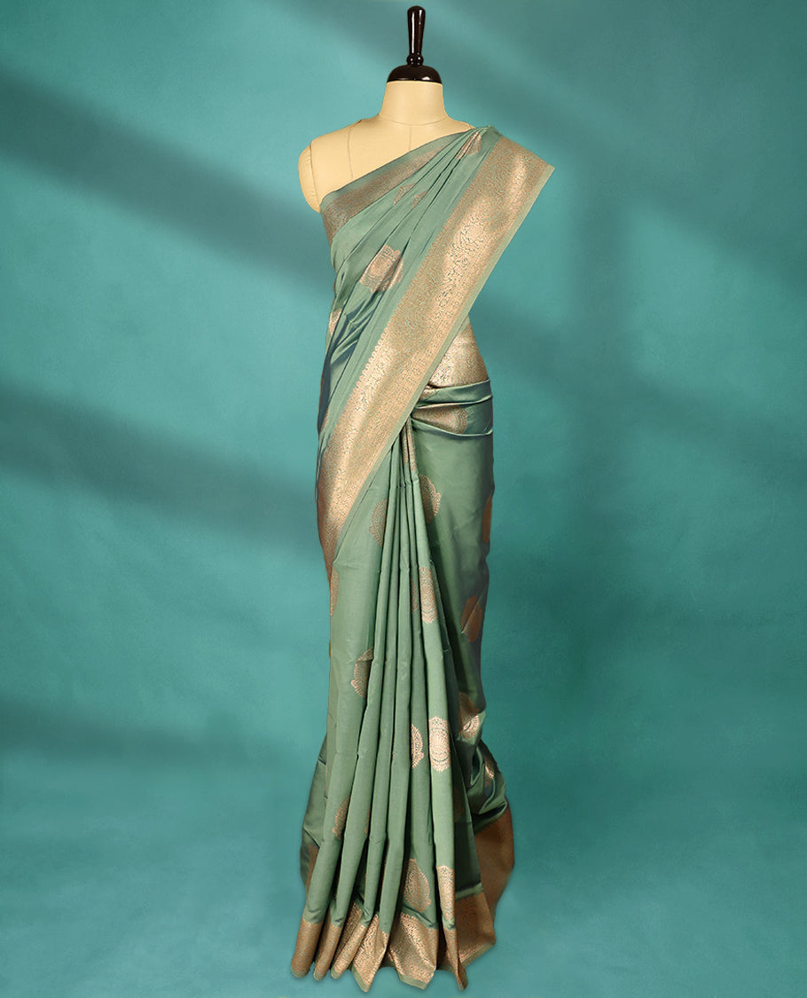 Pale Green coloured semi silk saree featuring a Golden Zari Butta design on the body, paired with a Self coloured border and matching blouse.
