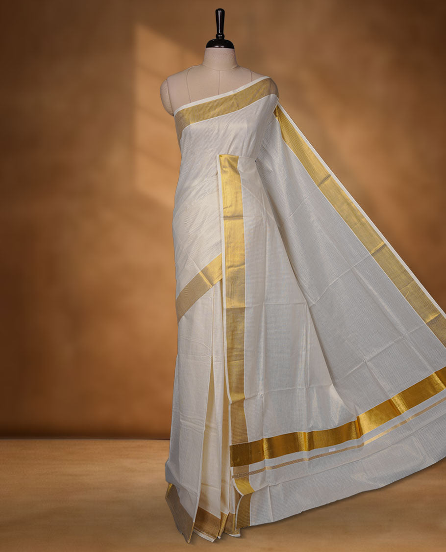 Off-white colour cotton Kerala saree crafted in a soft, sheer weave, finished with a classic rich gold kasavu border along the body and pallu, and paired with a matching blouse.